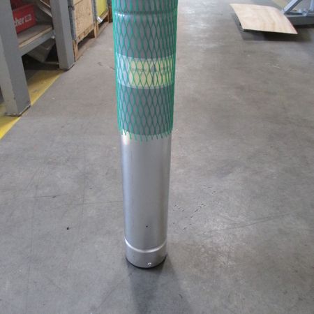 Eine 90er Bodenhülse mit grünem Schutzpapier in einer Lagerhalle