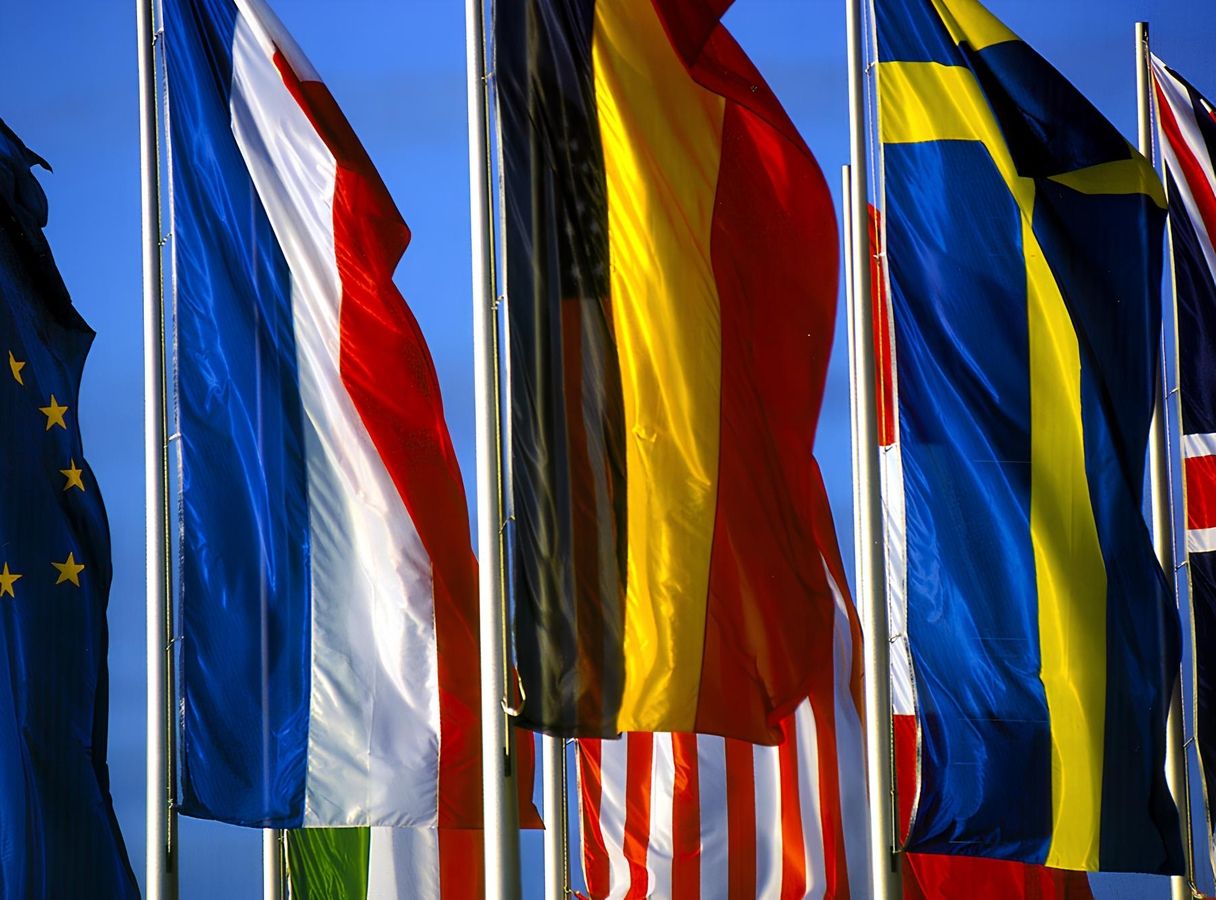 Mehrere Fahnen von europäischen Ländern in Nahaufnahme vor blauem Himmel im Hintergrund