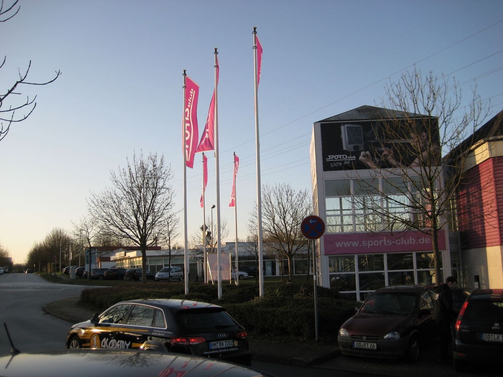 Rote Fahnen wehen an einem Fahnenmast vor einem Gebäude im Wind