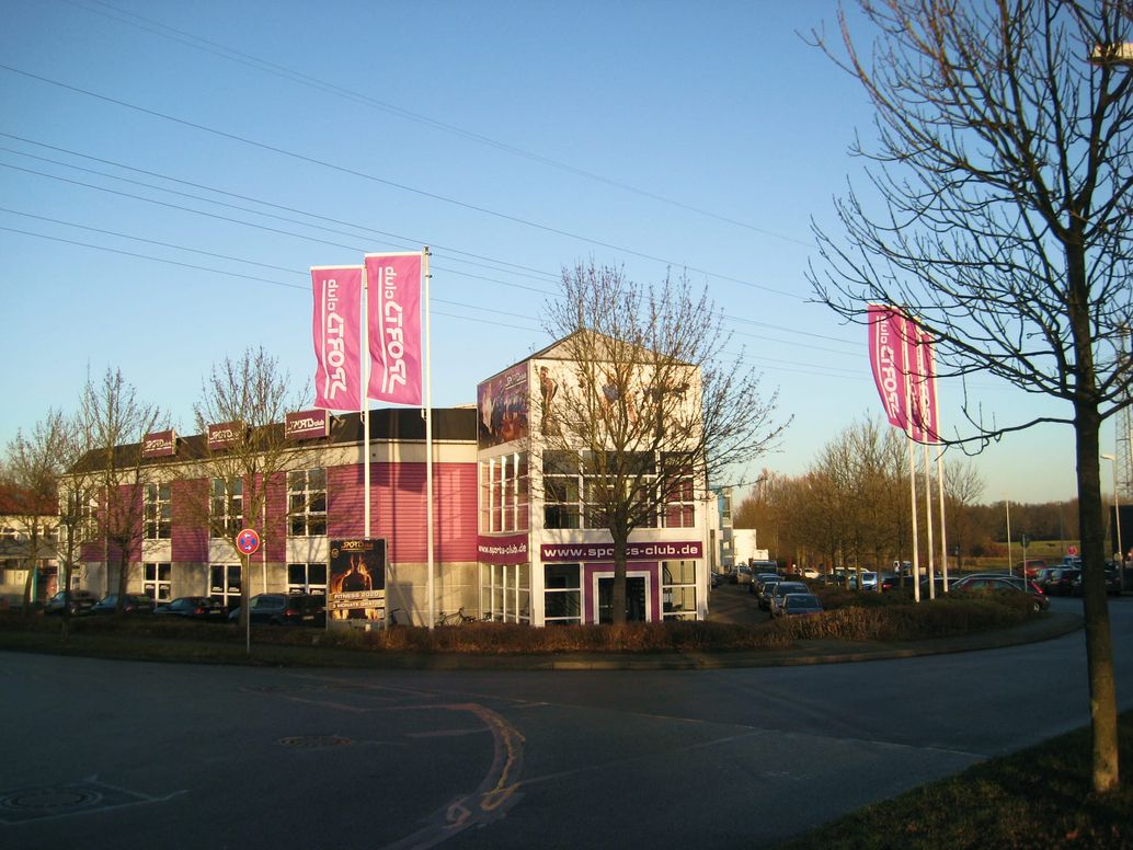 Rote Fahnen wehen an einem Fahnenmast vor einem Gebäude im Wind